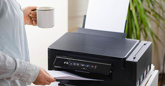 Office job. Secretary or office manager woman using printer, scanner or laser copy machine.